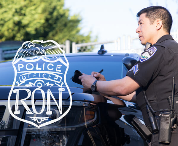 Officer Ron writing in a weatherproof notebook.