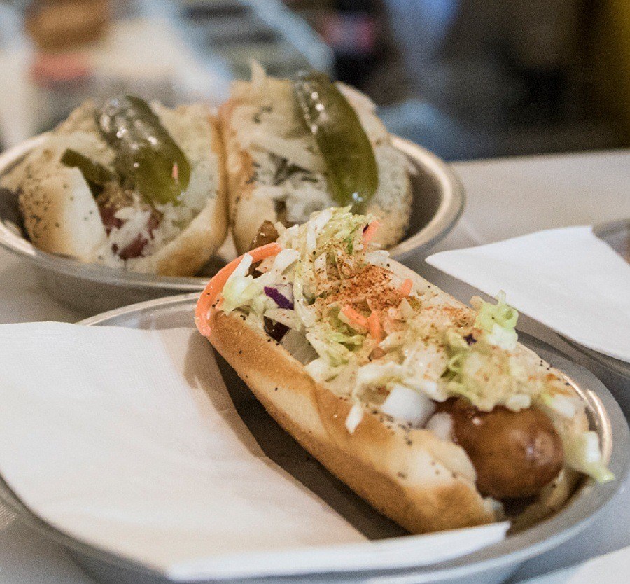 Gourmet hotdog loaded with toppings.