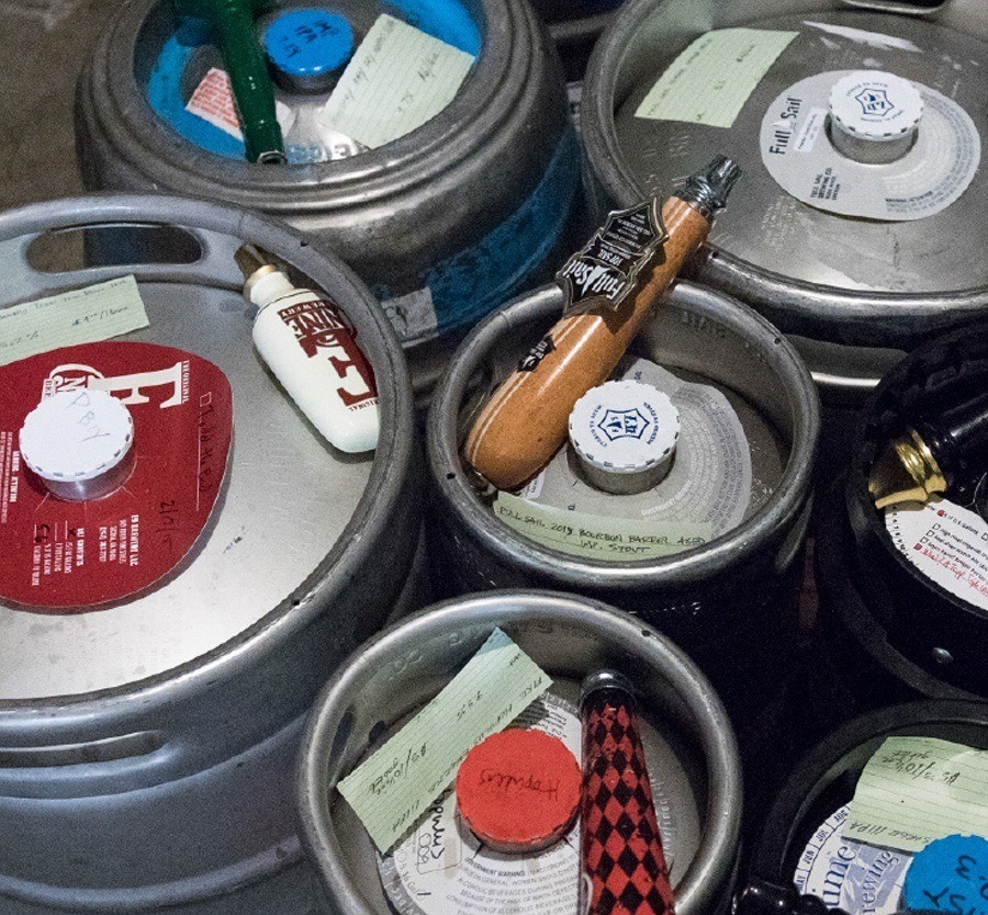 Kegs in a cooler with all-weather index cards on top of each one.