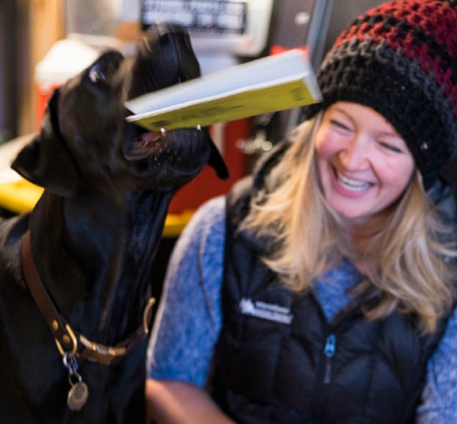 Adventure writer laughing as dog takes notebook.