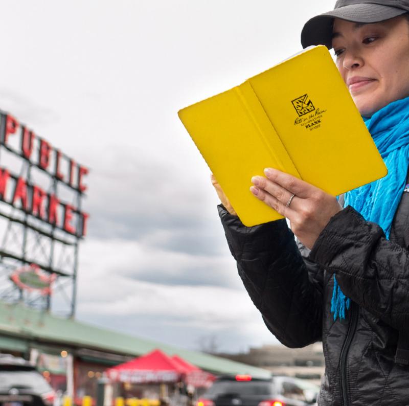 artist sketching in book at market