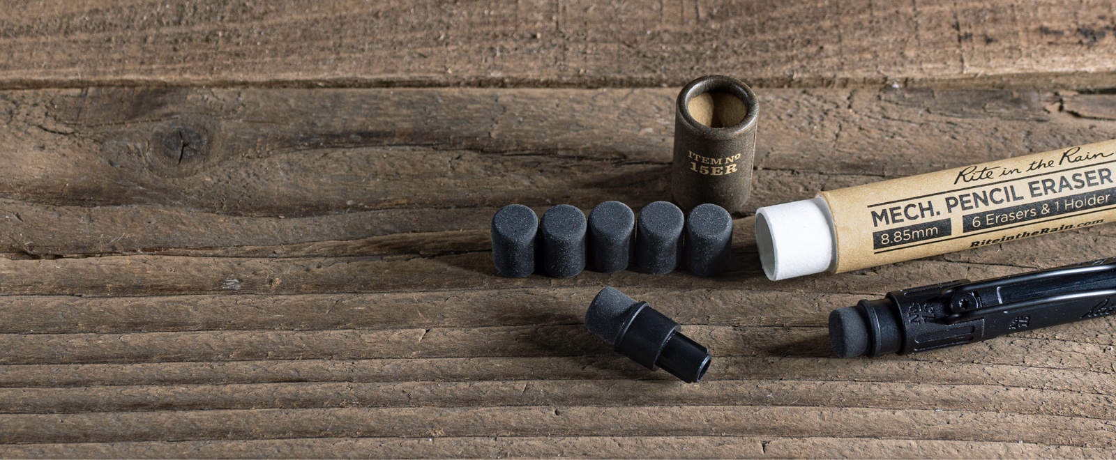 No. 15 Mechaical Pencil Erasers and storage tube laying on wood.